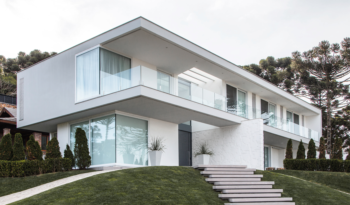 Casa tem interiores sóbrios e aberturas assimétricas na fachada